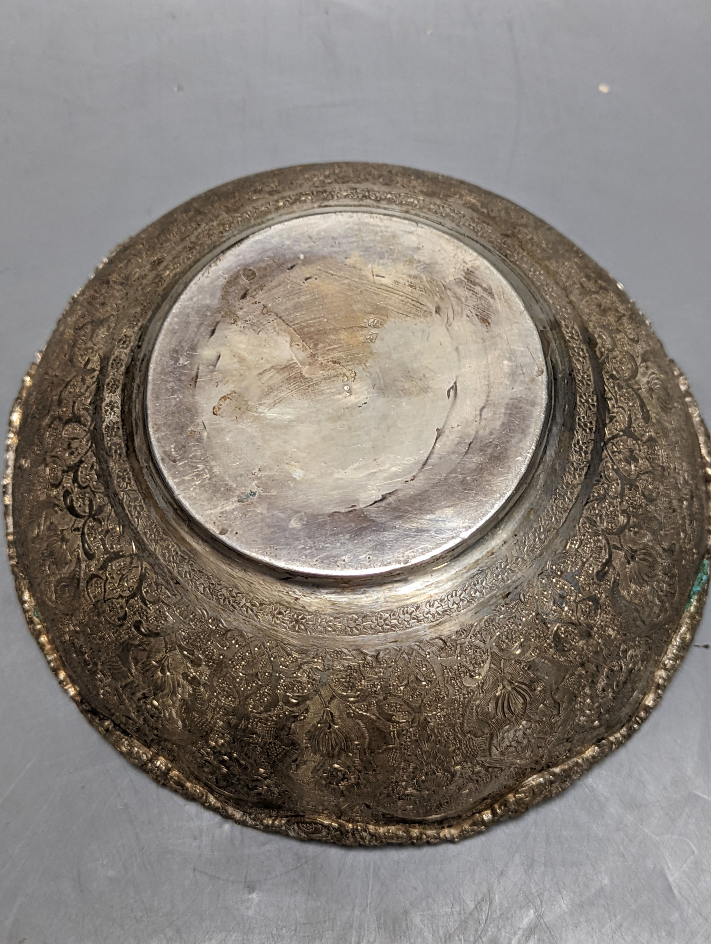 A Persian engraved white metal bowl, diameter 17.9cm and a similar stand or plate, 22cm, 20oz.